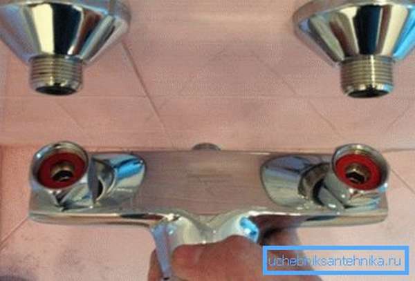 На фото показано, как закрепить смеситель на стене в ванной.